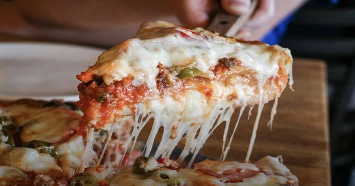 A slice of Oley's deep dish with a long cheese pull